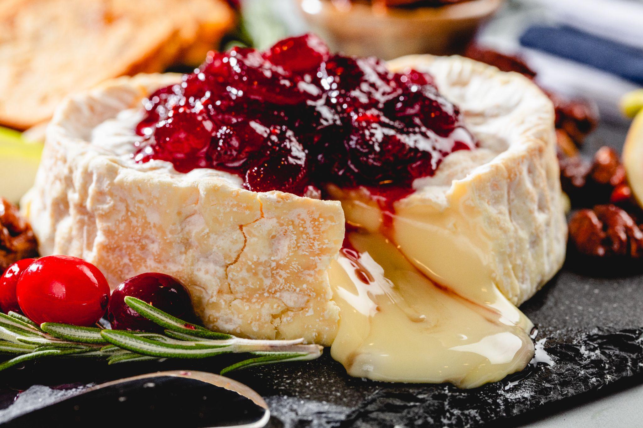 cranberry sauce made with C&H® Sugar on top of baked brie with candied pecans